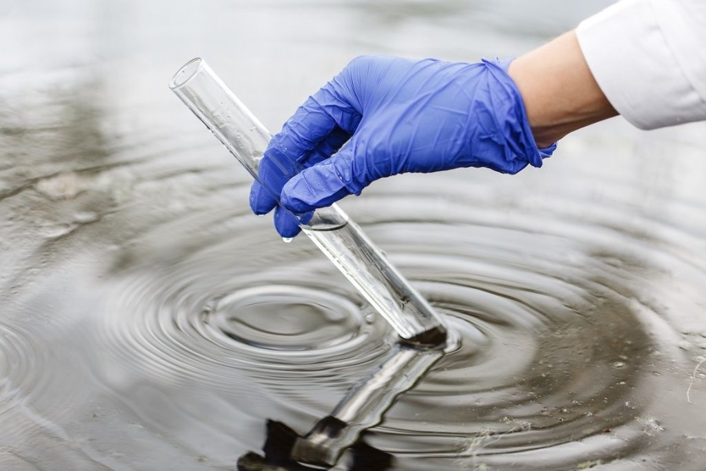 researcher-holds-test-tube-with-water-hand-blue-glove.jpg